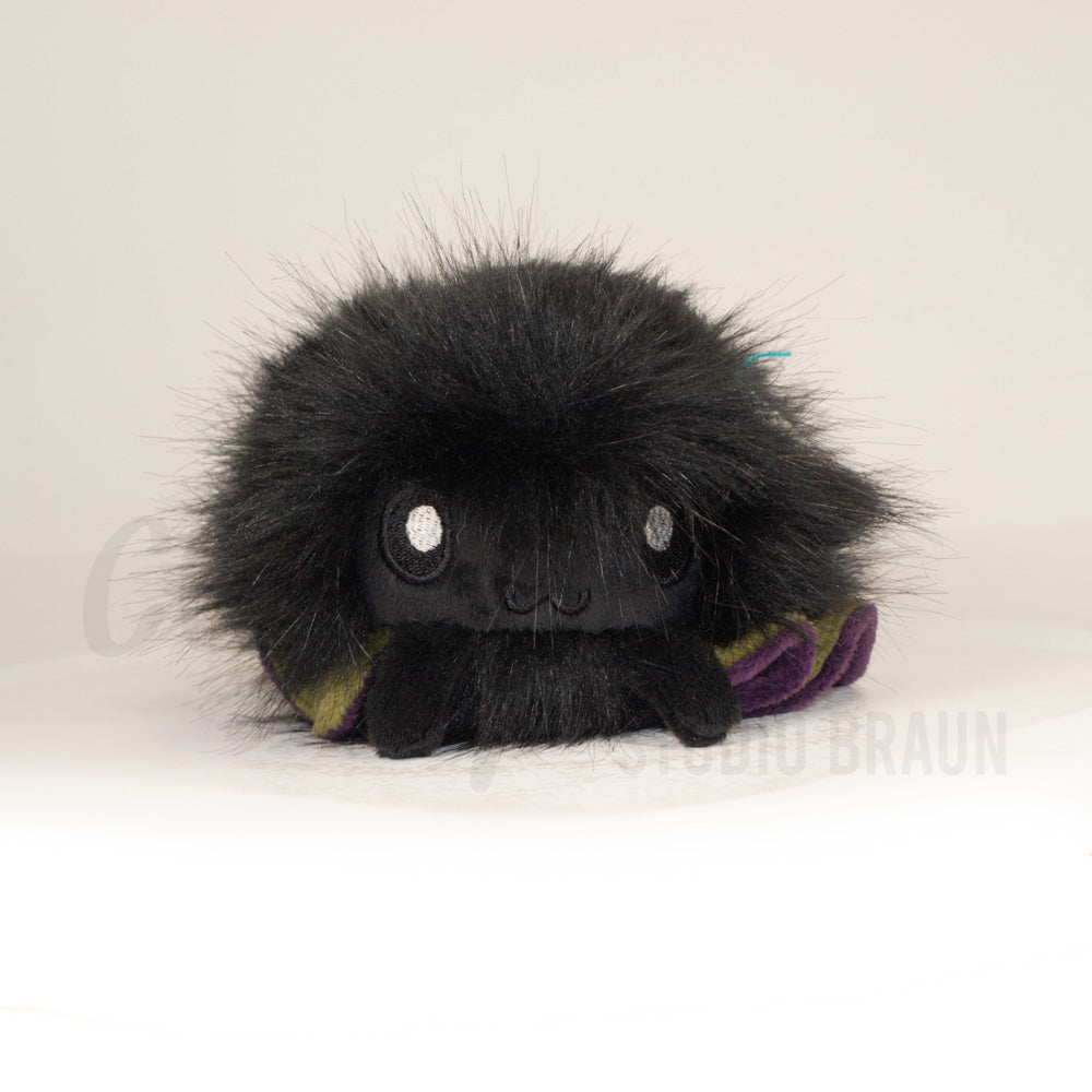 Front view of a cuttlepod plush toy, showcasing its unique form with large, cartoonish eyes, ruffled fins, and a cuddly, furry texture.