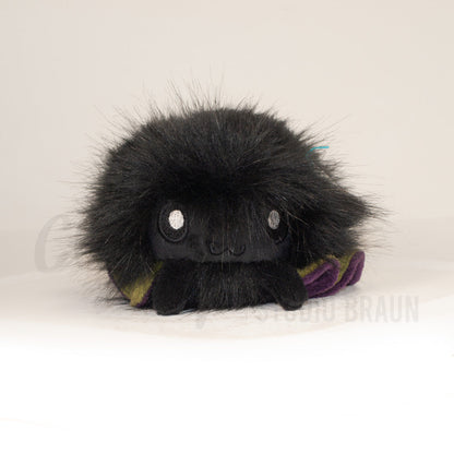 Front view of a cuttlepod plush toy, showcasing its unique form with large, cartoonish eyes, ruffled fins, and a cuddly, furry texture.