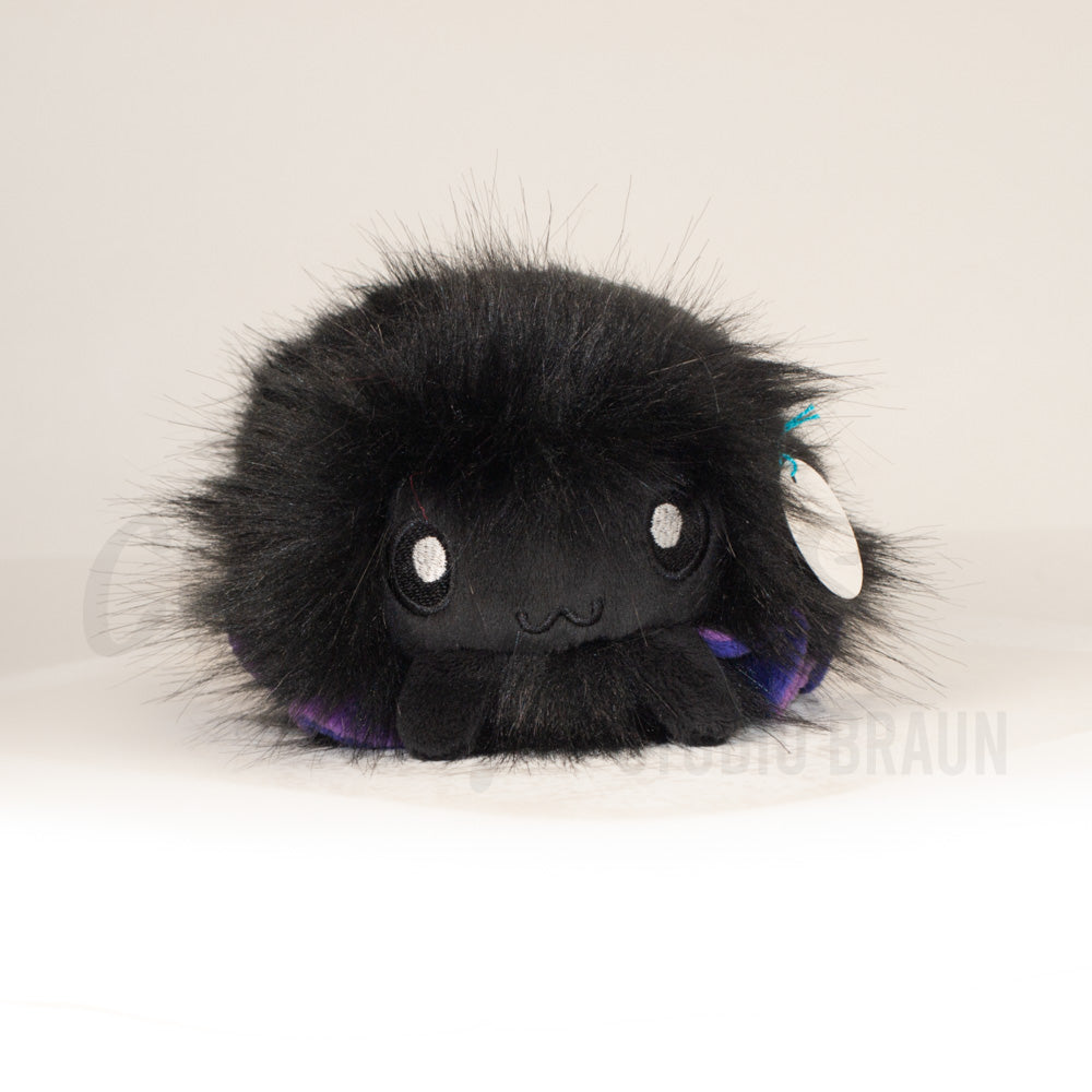 Front view of a cuttlepod plush toy, showcasing its unique form with large, cartoonish eyes, ruffled fins, and a cuddly, furry texture.