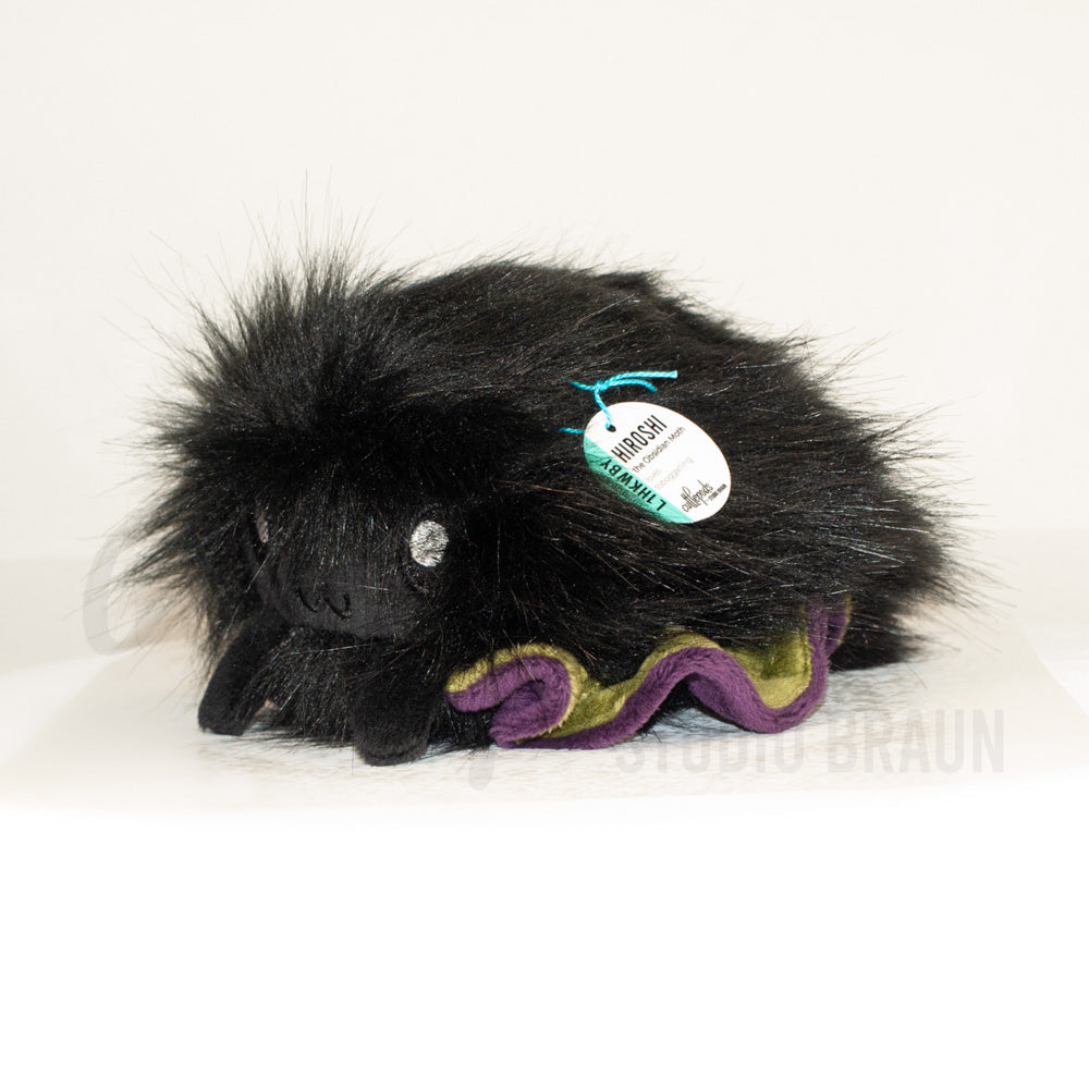 Front view of a cuttlepod plush toy, captured at a slight angle to highlight its charming features: large, cartoonish eyes, ruffled fins, and a cuddly, furry texture.