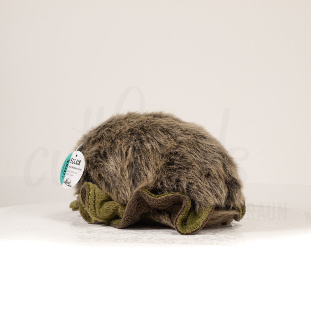 Slightly angled back view of a cuttlepod plush toy, highlighting two-tone ruffled fins, and a cuddly, furry body that comes to a soft point at the rear.