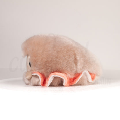 Side profile view of a cuttlepod plush toy, showcasing two-tone ruffled fins, and a cuddly, furry body.