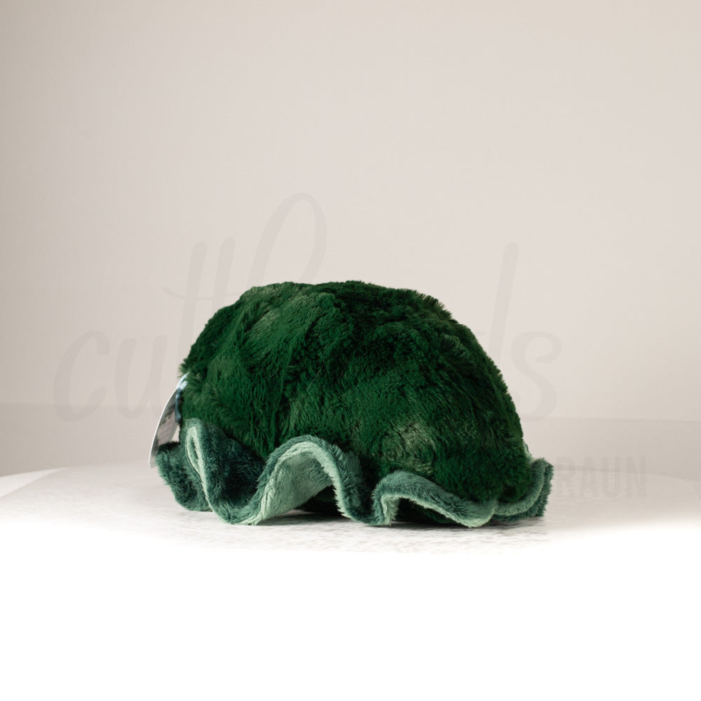 Slightly angled back view of a cuttlepod plush toy, highlighting two-tone ruffled fins, and a cuddly, furry body that comes to a soft point at the rear.