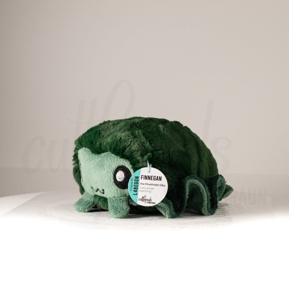 Front view of a cuttlepod plush toy, captured at a slight angle to highlight its charming features: large, cartoonish eyes, ruffled fins, and a cuddly, furry texture.