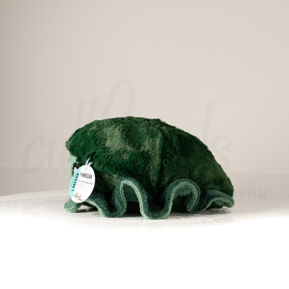 Side profile view of a cuttlepod plush toy, showcasing two-tone ruffled fins, and a cuddly, furry body.