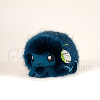 Front view of a cuttlepod plush toy, captured at a slight angle to highlight its charming features: large, cartoonish eyes, ruffled fins, and a cuddly, furry texture.