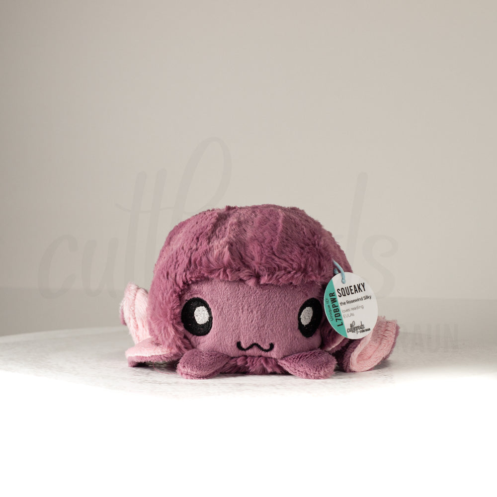 Front view of a cuttlepod plush toy, showcasing its unique form with large, cartoonish eyes, ruffled fins, and a cuddly, furry texture.