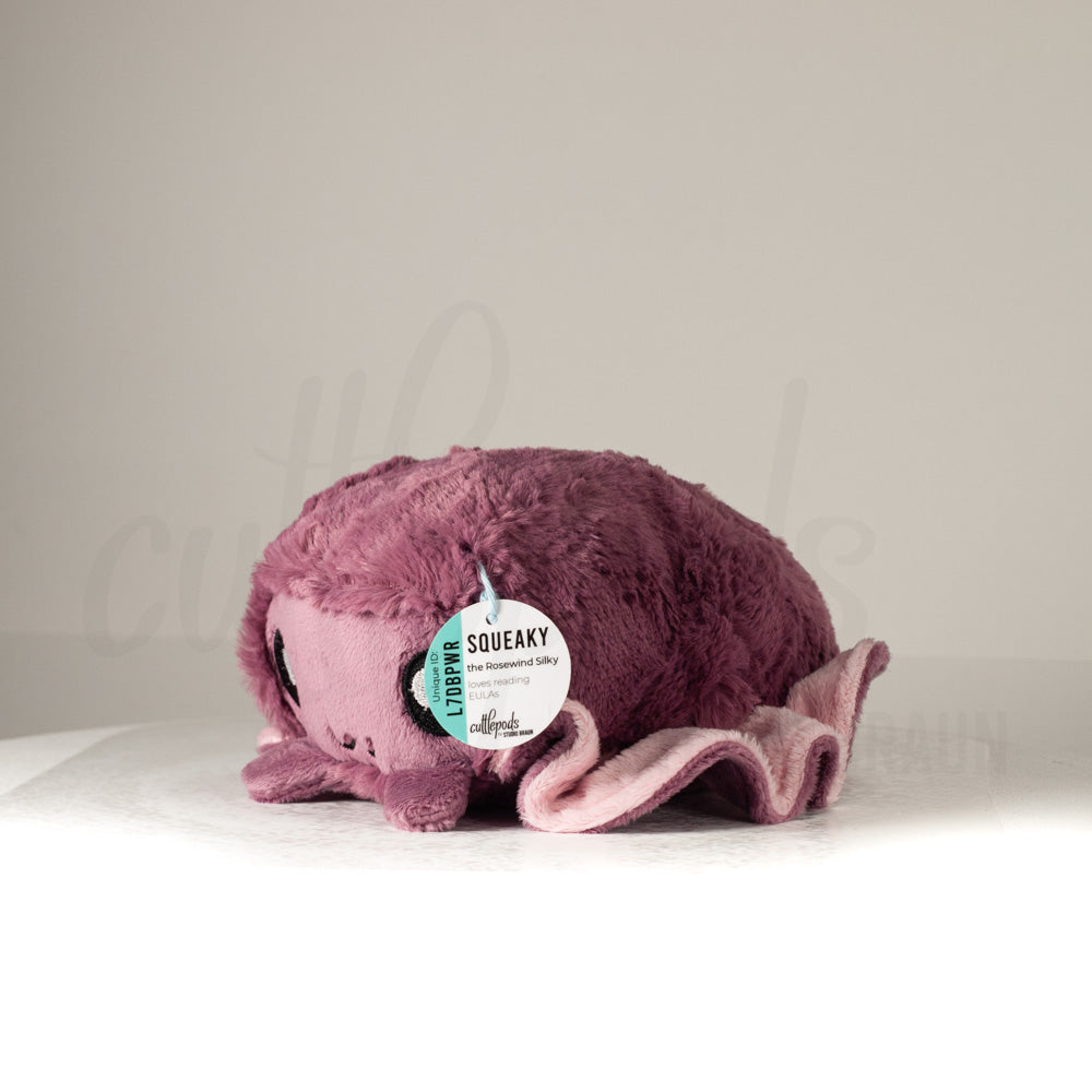 Front view of a cuttlepod plush toy, captured at a slight angle to highlight its charming features: large, cartoonish eyes, ruffled fins, and a cuddly, furry texture.