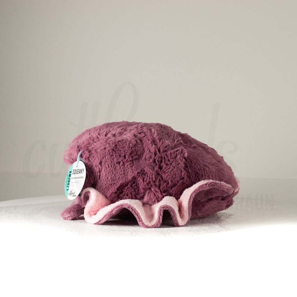 Side profile view of a cuttlepod plush toy, showcasing two-tone ruffled fins, and a cuddly, furry body.