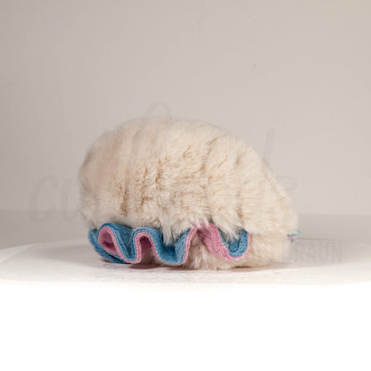 Slightly angled back view of a cuttlepod plush toy, highlighting two-tone ruffled fins, and a cuddly, furry body that comes to a soft point at the rear.