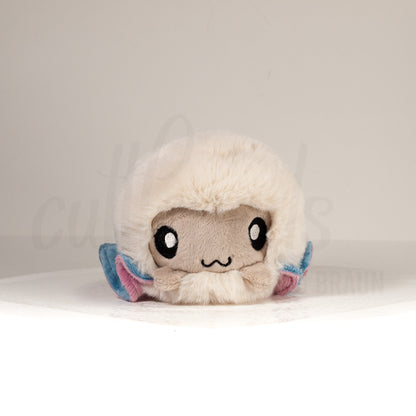 Front view of a cuttlepod plush toy, showcasing its unique form with large, cartoonish eyes, ruffled fins, and a cuddly, furry texture.