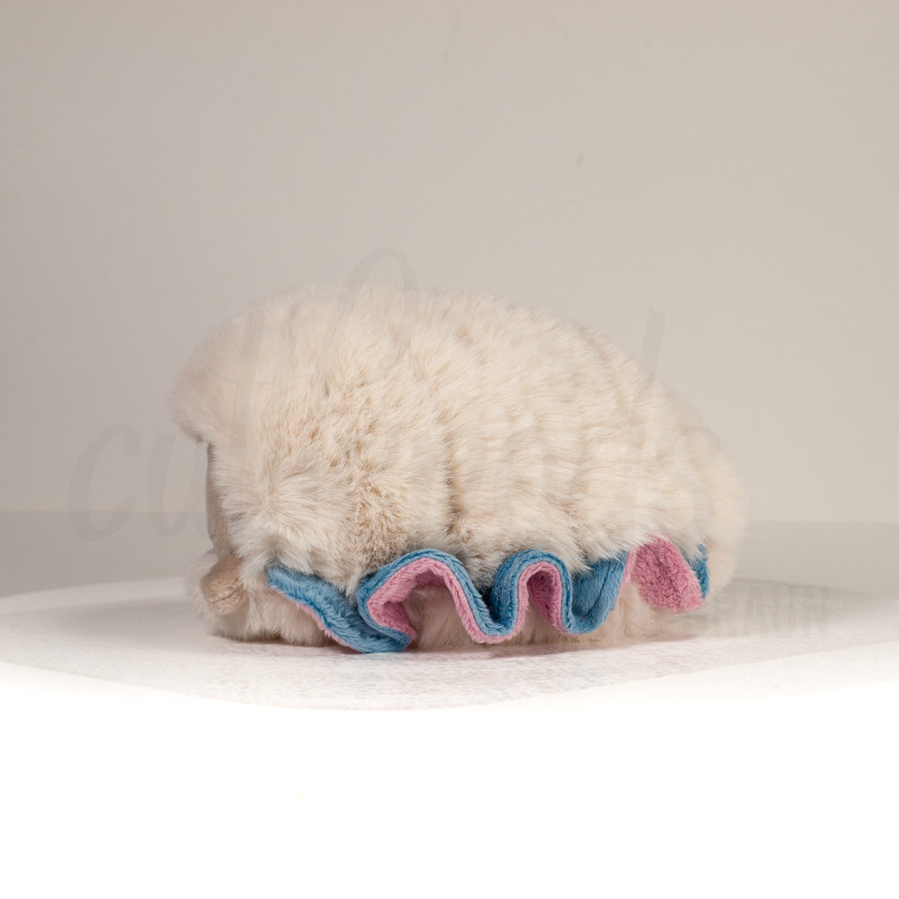 Side profile view of a cuttlepod plush toy, showcasing two-tone ruffled fins, and a cuddly, furry body.