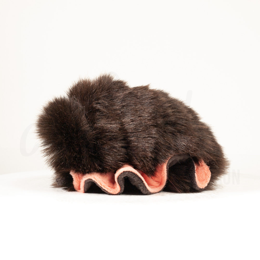 Side profile view of a cuttlepod plush toy, showcasing two-tone ruffled fins, and a cuddly, furry body.