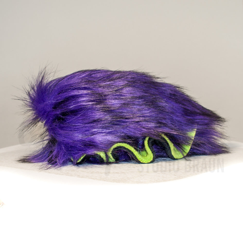 Side profile view of a cuttlepod plush toy, showcasing two-tone ruffled fins, and a cuddly, furry body.