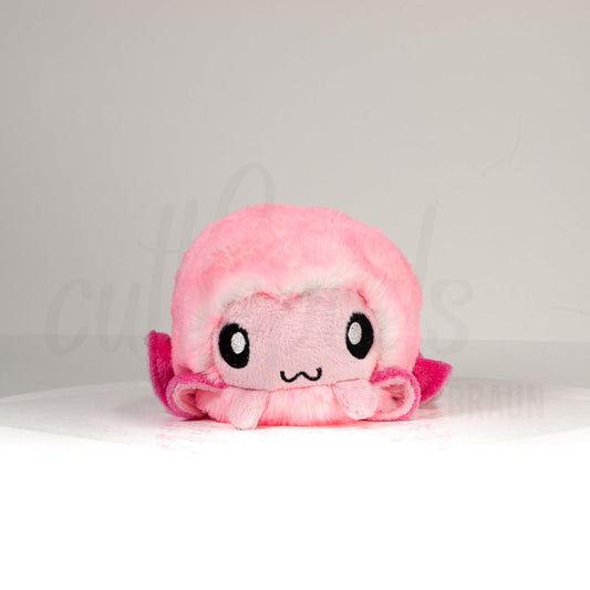 Front view of a cuttlepod plush toy, showcasing its unique form with large, cartoonish eyes, ruffled fins, and a cuddly, furry texture.