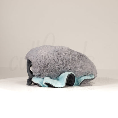 Side profile view of a cuttlepod plush toy, showcasing two-tone ruffled fins, and a cuddly, furry body.