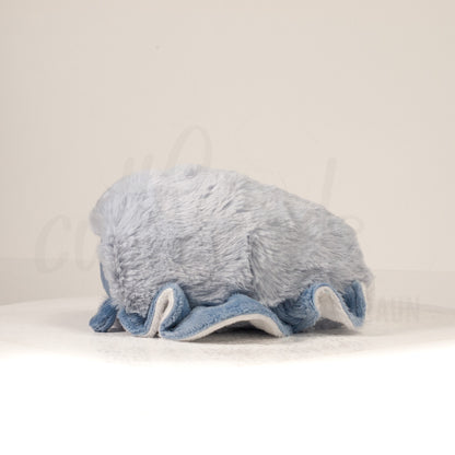 Side profile view of a cuttlepod plush toy, showcasing two-tone ruffled fins, and a cuddly, furry body.