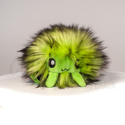 Front view of a cuttlepod plush toy, showcasing its unique form with large, cartoonish eyes, ruffled fins, and a cuddly, furry texture.