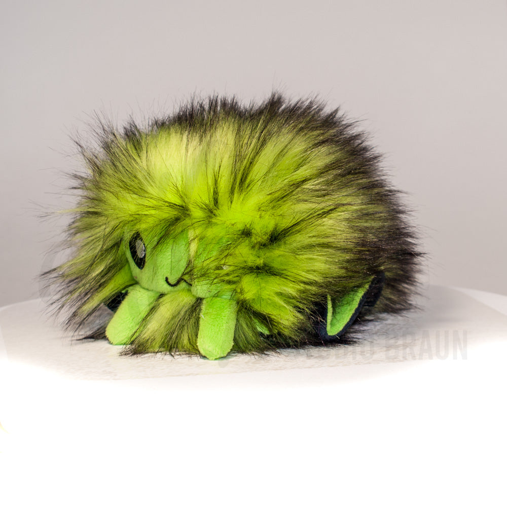 Front view of a cuttlepod plush toy, captured at a slight angle to highlight its charming features: large, cartoonish eyes, ruffled fins, and a cuddly, furry texture.