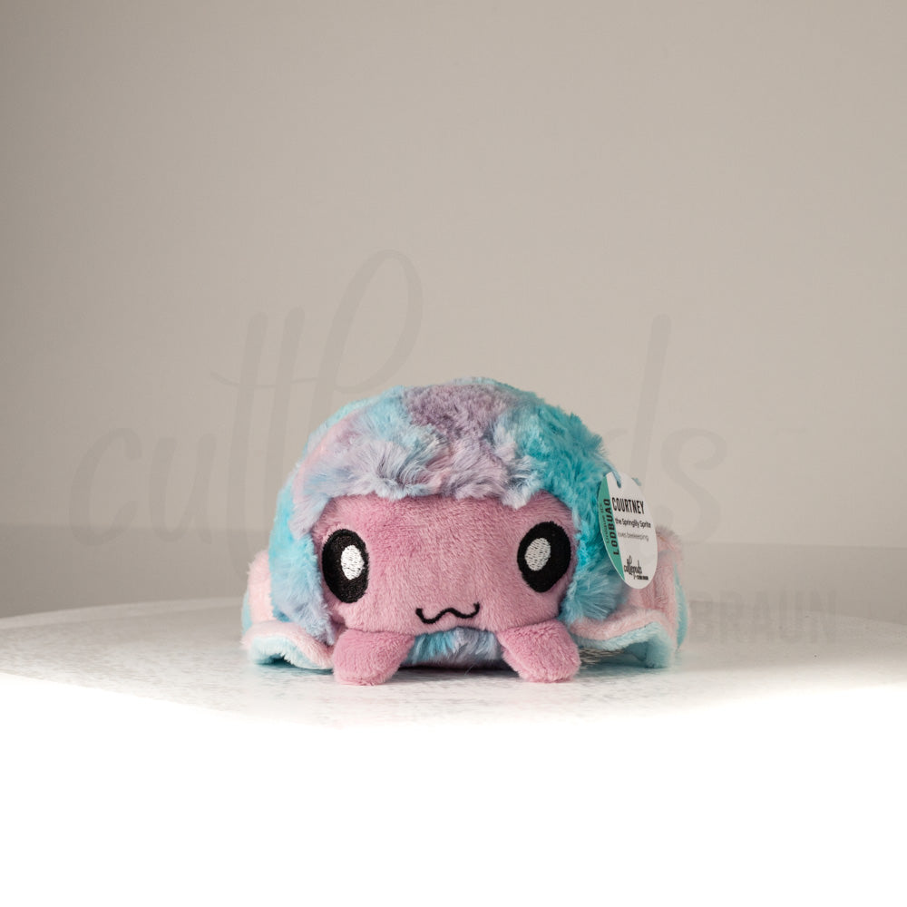 Front view of a cuttlepod plush toy, showcasing its unique form with large, cartoonish eyes, ruffled fins, and a cuddly, furry texture.