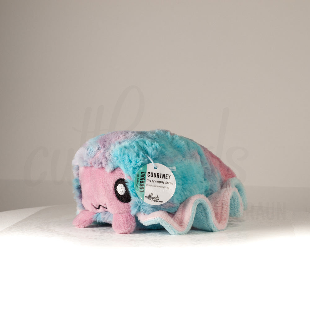 Front view of a cuttlepod plush toy, captured at a slight angle to highlight its charming features: large, cartoonish eyes, ruffled fins, and a cuddly, furry texture.