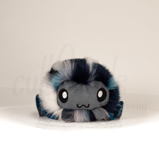 Front view of a cuttlepod plush toy, showcasing its unique form with large, cartoonish eyes, ruffled fins, and a cuddly, furry texture.