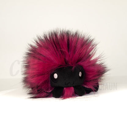 Front view of a cuttlepod plush toy, showcasing its unique form with large, cartoonish eyes, ruffled fins, and a cuddly, furry texture.