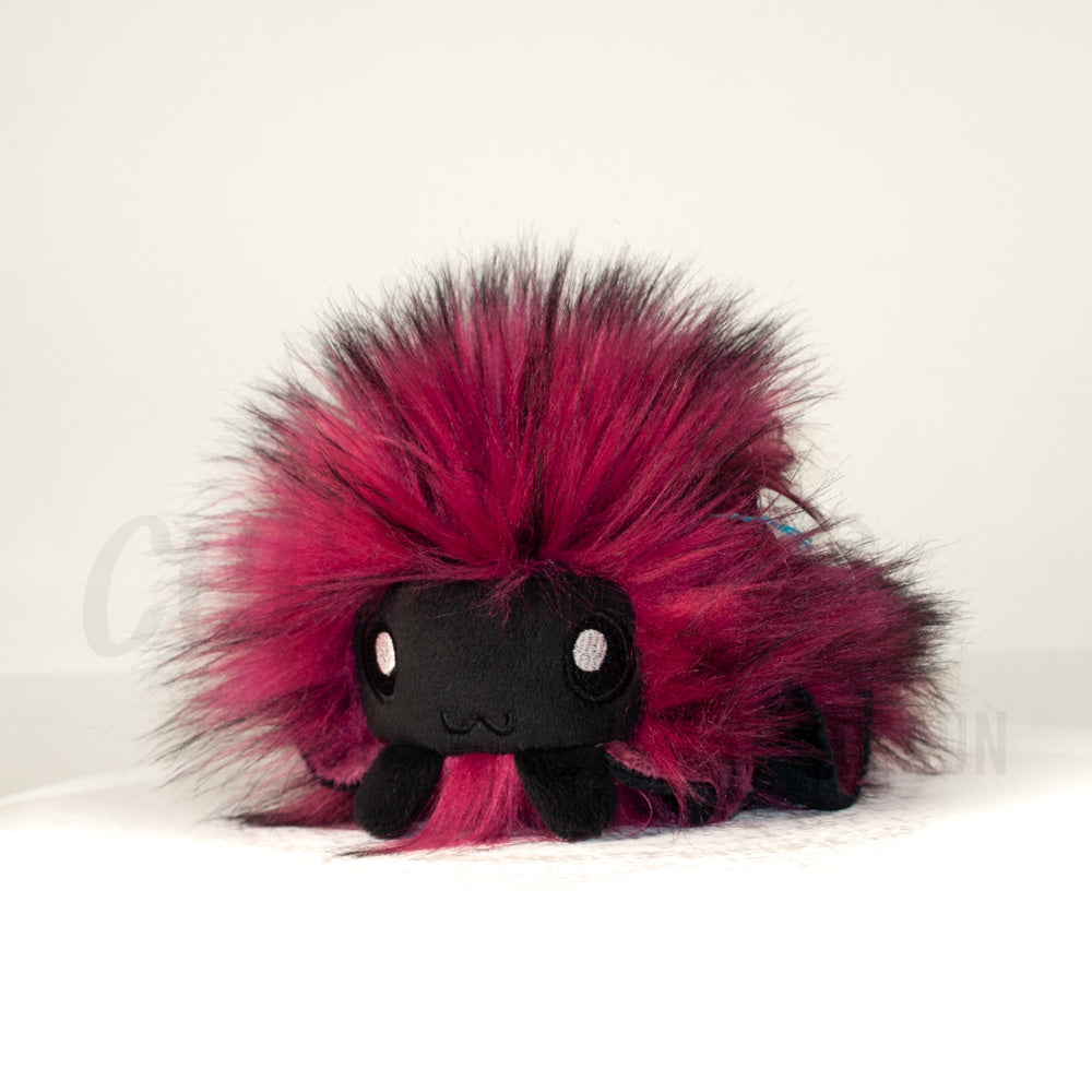 Front view of a cuttlepod plush toy, captured at a slight angle to highlight its charming features: large, cartoonish eyes, ruffled fins, and a cuddly, furry texture.