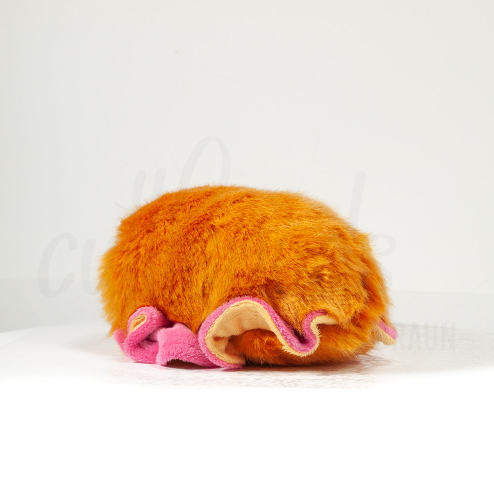 Slightly angled back view of a cuttlepod plush toy, highlighting two-tone ruffled fins, and a cuddly, furry body that comes to a soft point at the rear.