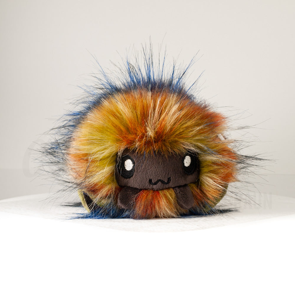 Front view of a cuttlepod plush toy, showcasing its unique form with large, cartoonish eyes, ruffled fins, and a cuddly, furry texture.