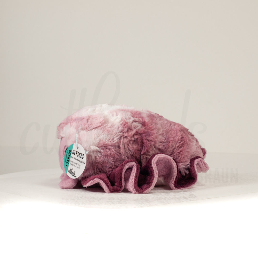 Side profile view of a cuttlepod plush toy, showcasing two-tone ruffled fins, and a cuddly, furry body.