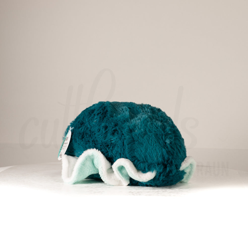 Slightly angled back view of a cuttlepod plush toy, highlighting two-tone ruffled fins, and a cuddly, furry body that comes to a soft point at the rear.