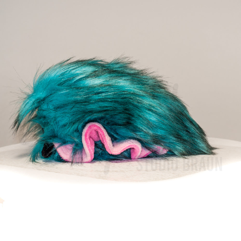 Side profile view of a cuttlepod plush toy, showcasing two-tone ruffled fins, and a cuddly, furry body.