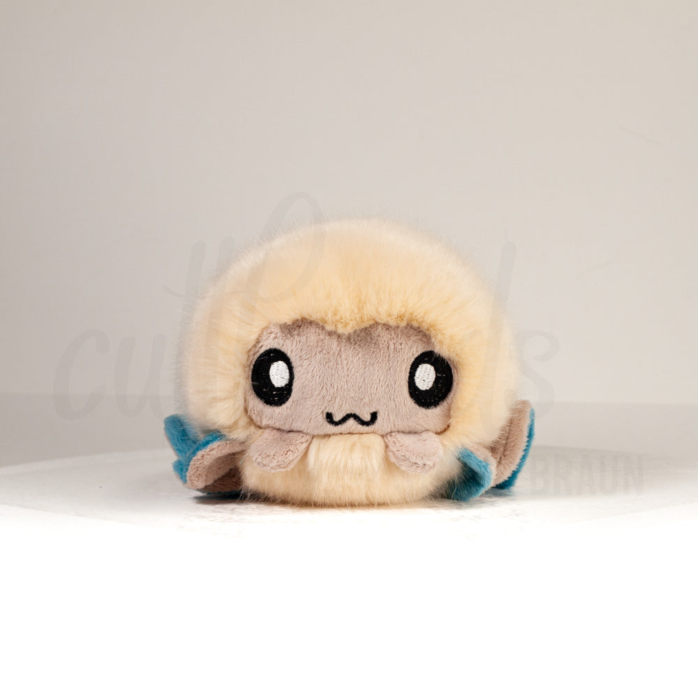 Front view of a cuttlepod plush toy, showcasing its unique form with large, cartoonish eyes, ruffled fins, and a cuddly, furry texture.