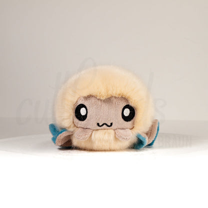 Front view of a cuttlepod plush toy, showcasing its unique form with large, cartoonish eyes, ruffled fins, and a cuddly, furry texture.