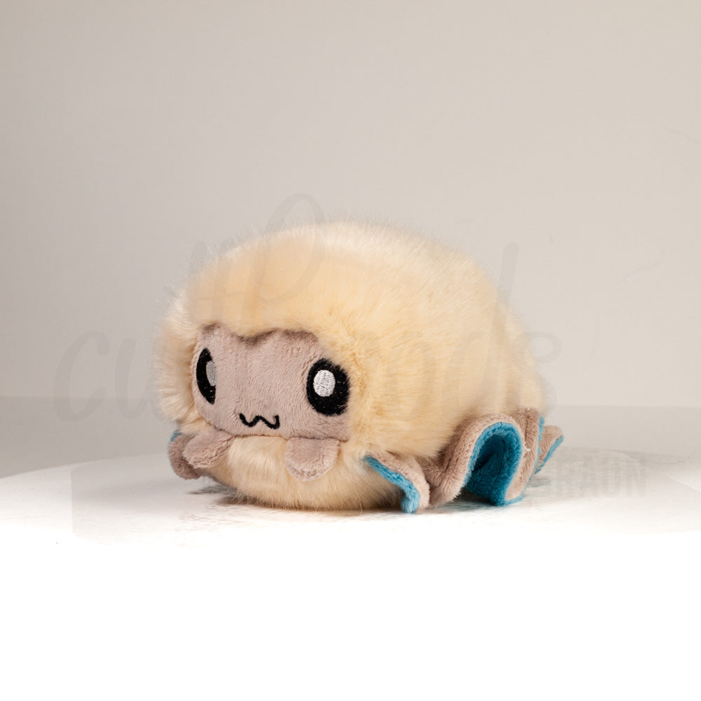 Front view of a cuttlepod plush toy, captured at a slight angle to highlight its charming features: large, cartoonish eyes, ruffled fins, and a cuddly, furry texture.