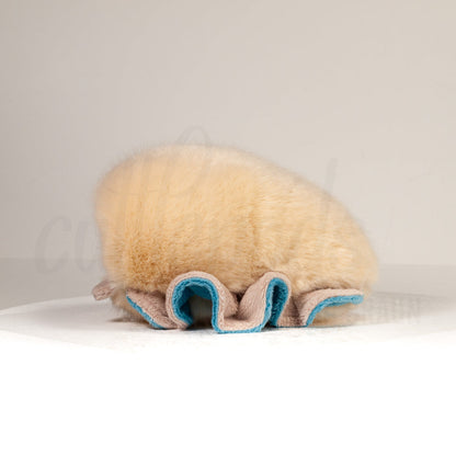 Side profile view of a cuttlepod plush toy, showcasing two-tone ruffled fins, and a cuddly, furry body.