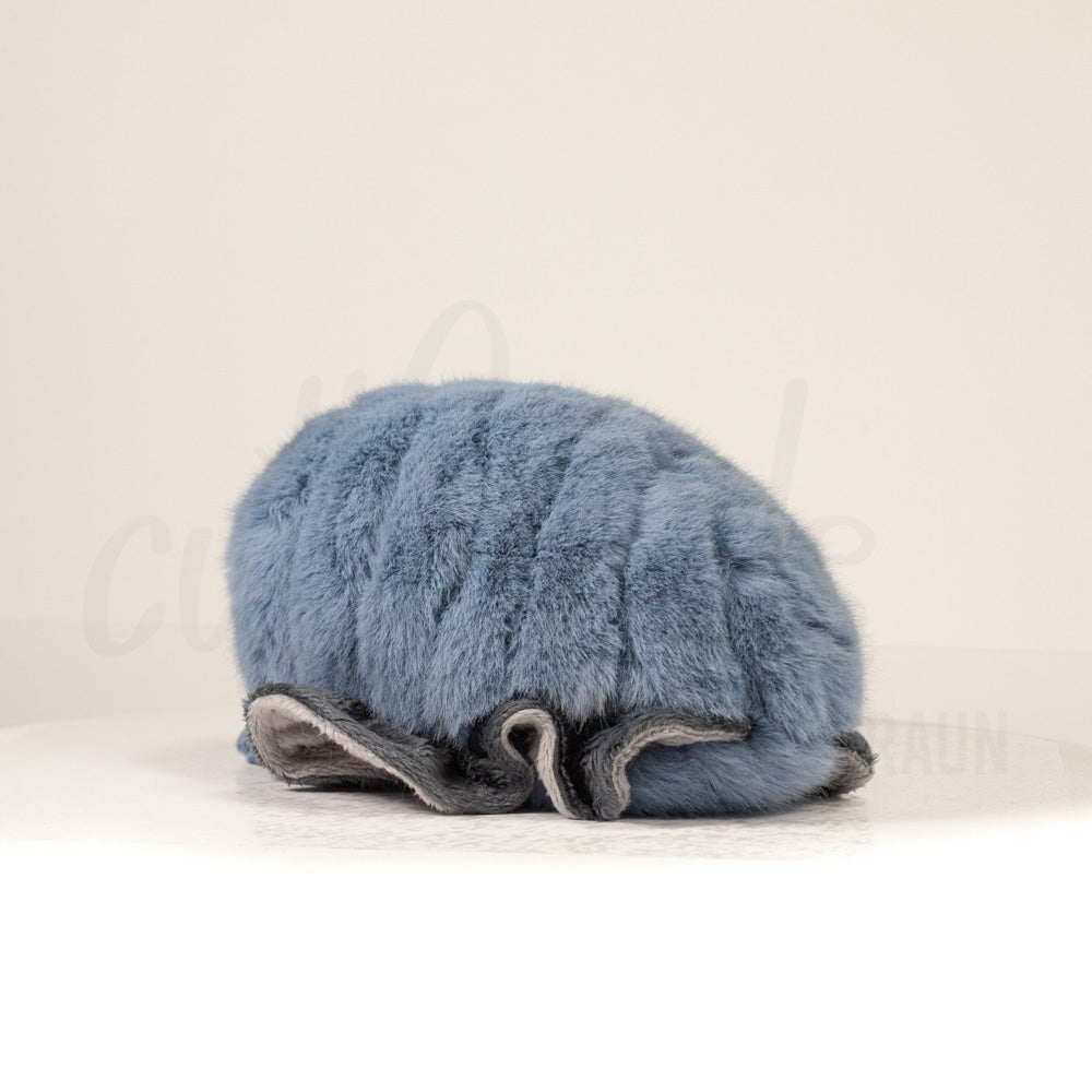 Slightly angled back view of a cuttlepod plush toy, highlighting two-tone ruffled fins, and a cuddly, furry body that comes to a soft point at the rear.