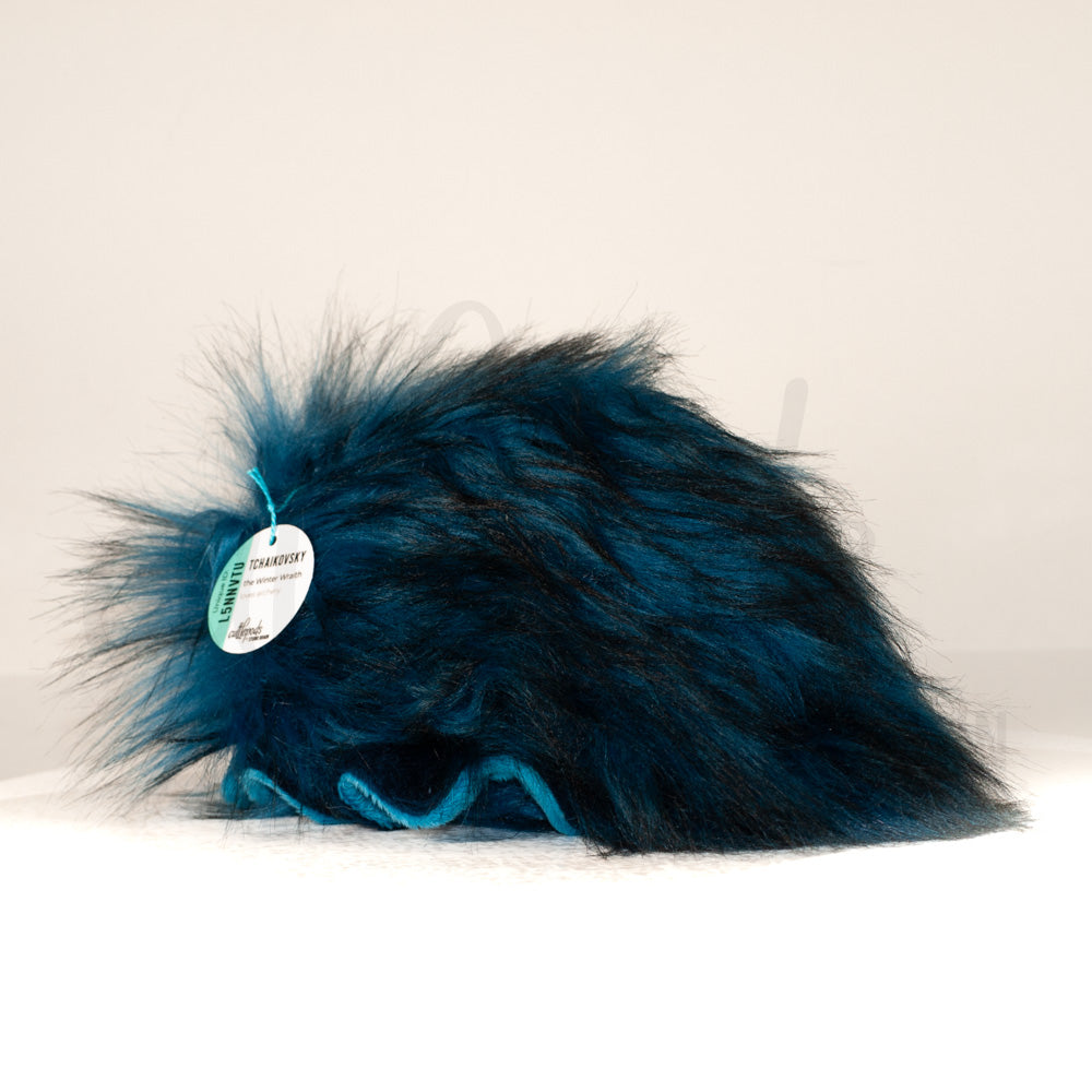 Slightly angled back view of a cuttlepod plush toy, highlighting two-tone ruffled fins, and a cuddly, furry body that comes to a soft point at the rear.