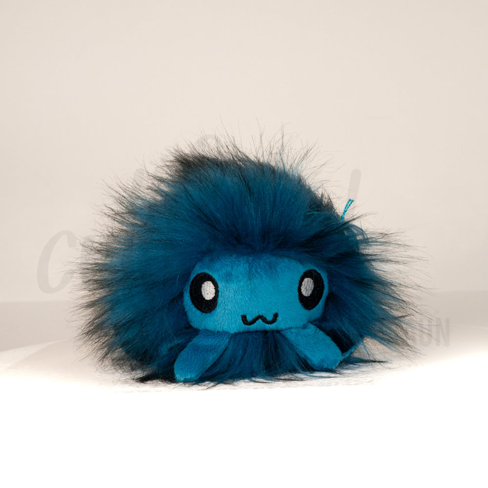 Front view of a cuttlepod plush toy, showcasing its unique form with large, cartoonish eyes, ruffled fins, and a cuddly, furry texture.