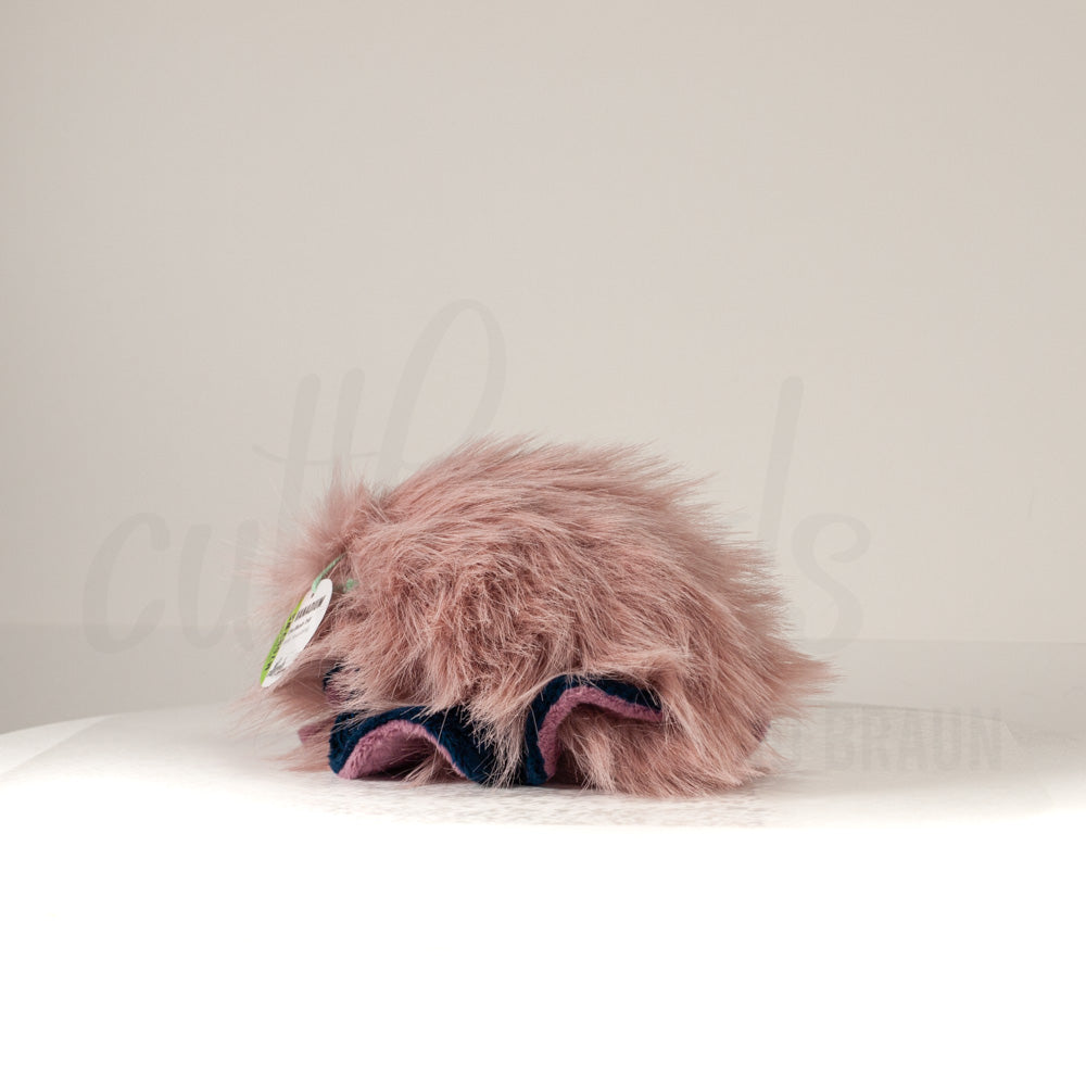 Slightly angled back view of a cuttlepod plush toy, highlighting two-tone ruffled fins, and a cuddly, furry body that comes to a soft point at the rear.