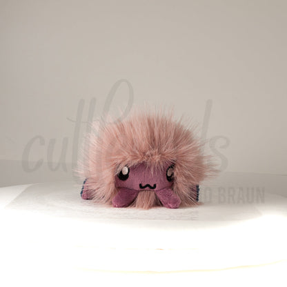 Front view of a cuttlepod plush toy, showcasing its unique form with large, cartoonish eyes, ruffled fins, and a cuddly, furry texture.