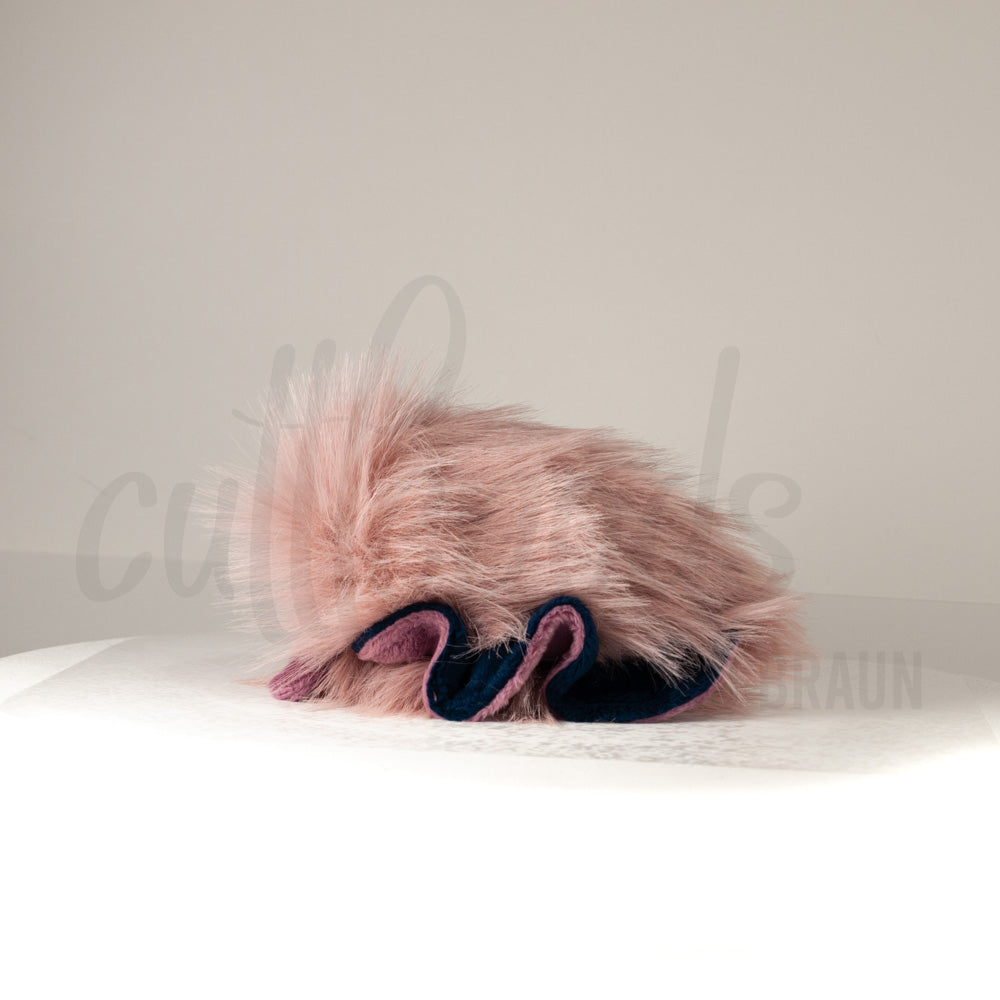 Side profile view of a cuttlepod plush toy, showcasing two-tone ruffled fins, and a cuddly, furry body.