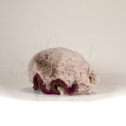 Slightly angled back view of a cuttlepod plush toy, highlighting two-tone ruffled fins, and a cuddly, furry body that comes to a soft point at the rear.