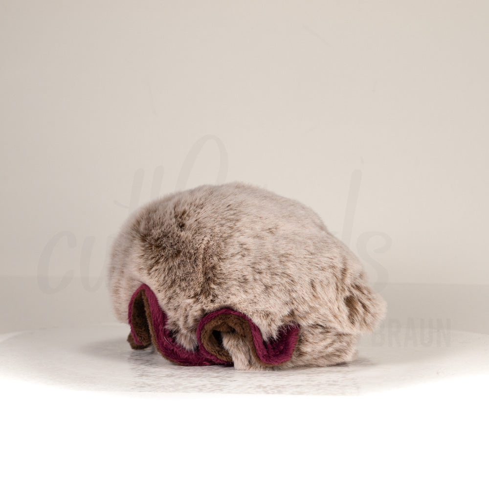 Slightly angled back view of a cuttlepod plush toy, highlighting two-tone ruffled fins, and a cuddly, furry body that comes to a soft point at the rear.