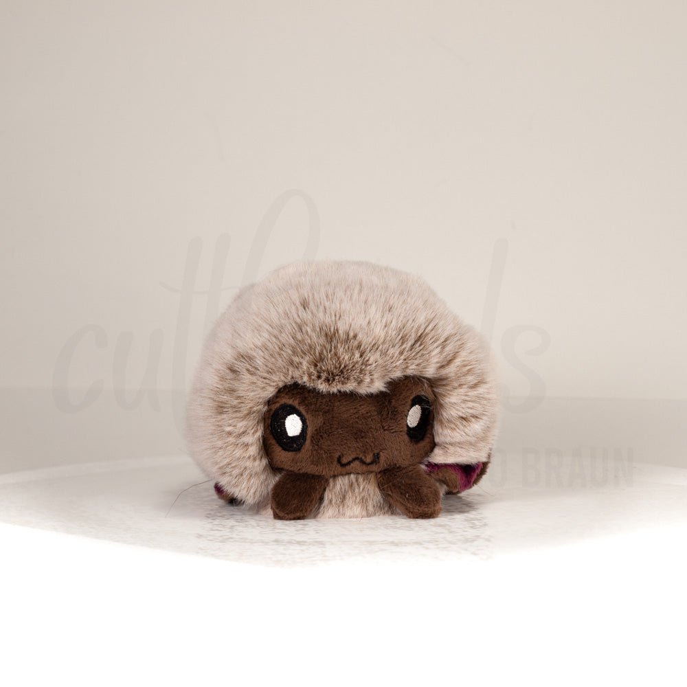 Front view of a cuttlepod plush toy, showcasing its unique form with large, cartoonish eyes, ruffled fins, and a cuddly, furry texture.