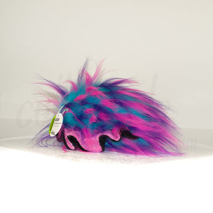 Slightly angled back view of a cuttlepod plush toy, highlighting two-tone ruffled fins, and a cuddly, furry body that comes to a soft point at the rear.