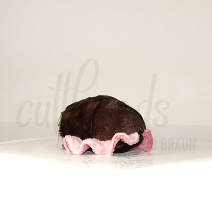 Slightly angled back view of a cuttlepod plush toy, highlighting two-tone ruffled fins, and a cuddly, furry body that comes to a soft point at the rear.