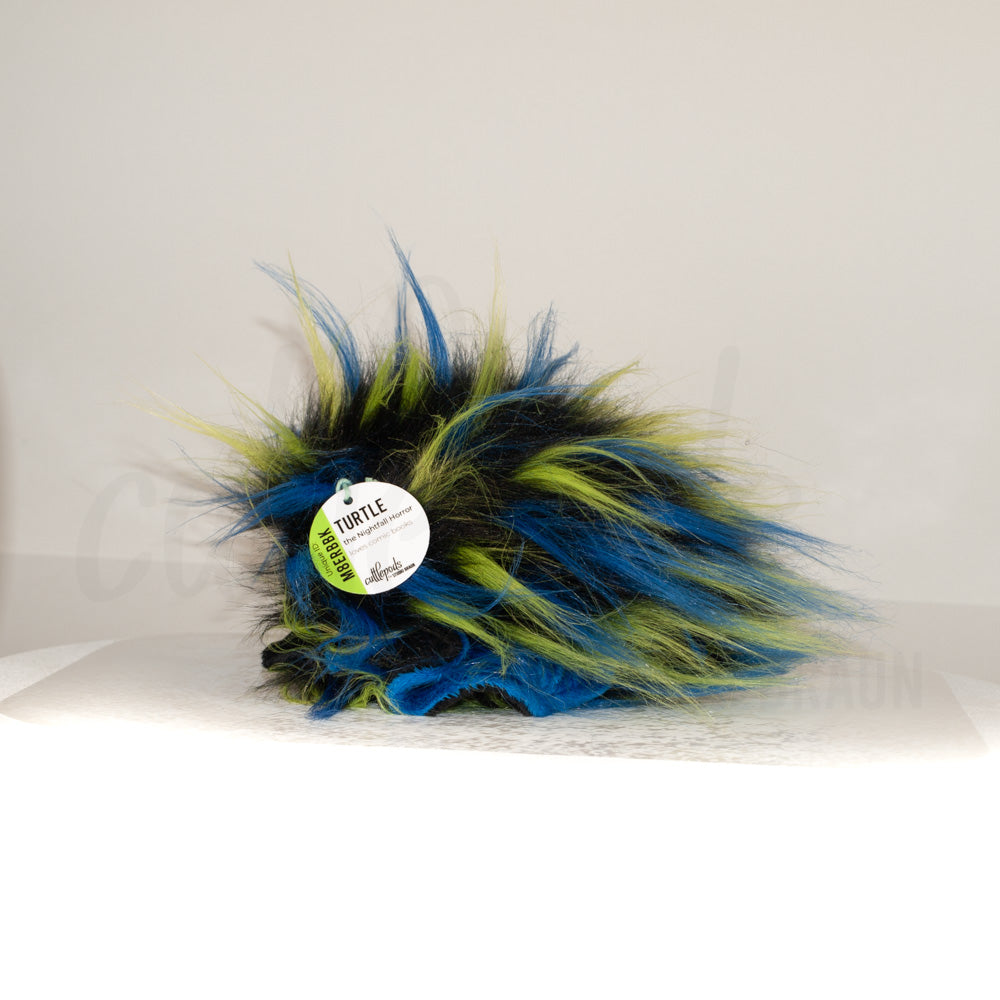 Side profile view of a cuttlepod plush toy, showcasing two-tone ruffled fins, and a cuddly, furry body.