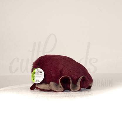 Slightly angled back view of a cuttlepod plush toy, highlighting two-tone ruffled fins, and a cuddly, furry body that comes to a soft point at the rear.